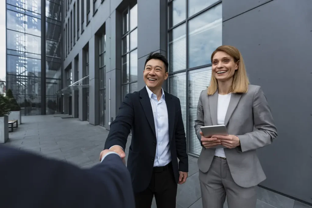 two marketing executives greeting a client